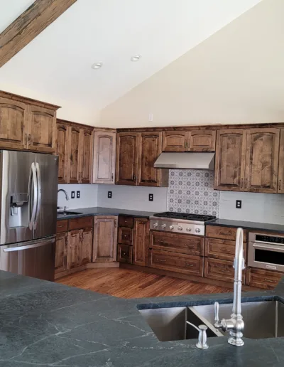 A kitchen with wood cabinets and a stainless steel sink.